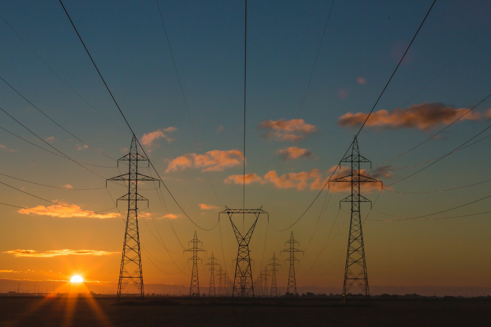 High-voltage power lines across a clear sky